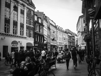 People on street amidst buildings in city