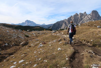 Rear view of hiker walking on mountain