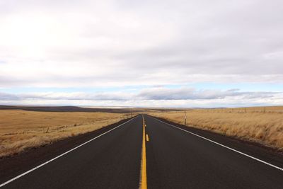 Empty road along countryside landscape