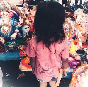 Full length of girl with toys for sale in market