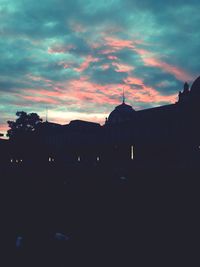 Buildings against cloudy sky at sunset