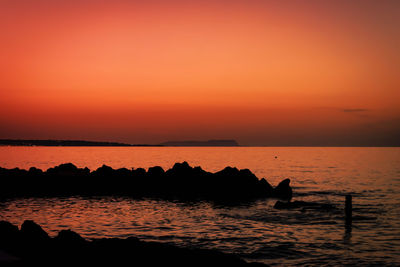 Scenic view of sea against orange sky