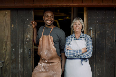 Portrait of smiling multi-ethnic coworkers standing at store entrance