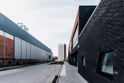 Empty street amidst buildings against sky