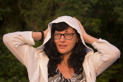 Portrait of beautiful smiling woman with hood at sunrise light