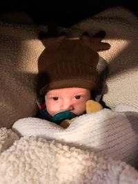 Portrait of cute baby boy lying on bed