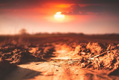 Surface level of land against sky during sunset