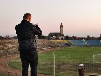 Rear view of man standing against sky during sunset