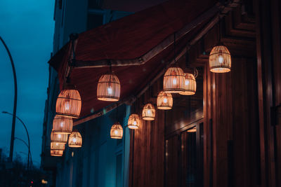 Low angle view of illuminated lanterns hanging on building