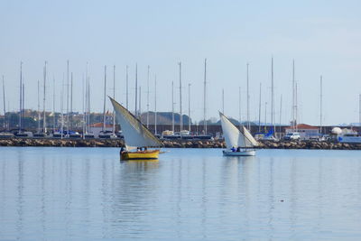 Boats on sea against clear sky