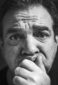 Close-up portrait of mature man against black background