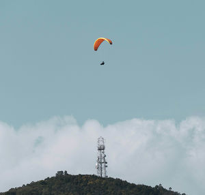 Low angle view of person paragliding against sky