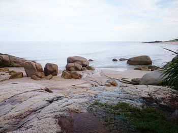 Rocks on sea shore against sky