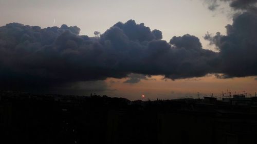 Silhouette cityscape against sky during sunset