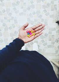 Cropped hand of person holding multi colored candies