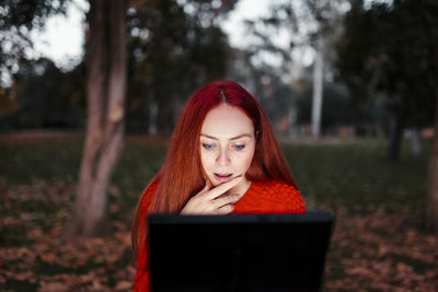 Portrait of young woman using phone outdoors