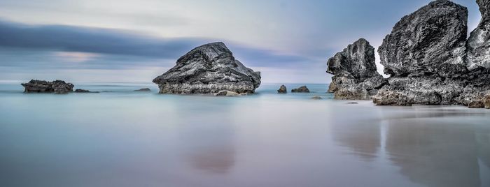 Panoramic view of rocks in sea against sky