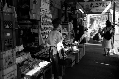 Rear view of people walking in market