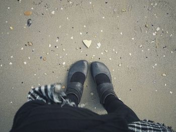 Low section of woman standing at beach