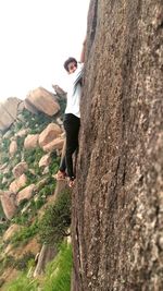 Full length of young woman on cliff against clear sky