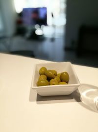 High angle view of green olives in bowl on table