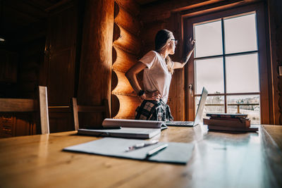 Rear view of woman sitting on table