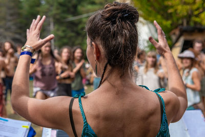 Rear view of woman with arms raised in background