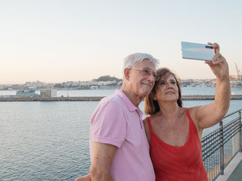 Senior couple making selfie during a walk through the seaport
