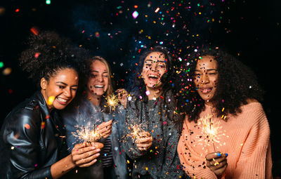 Friends holding sparklers at party