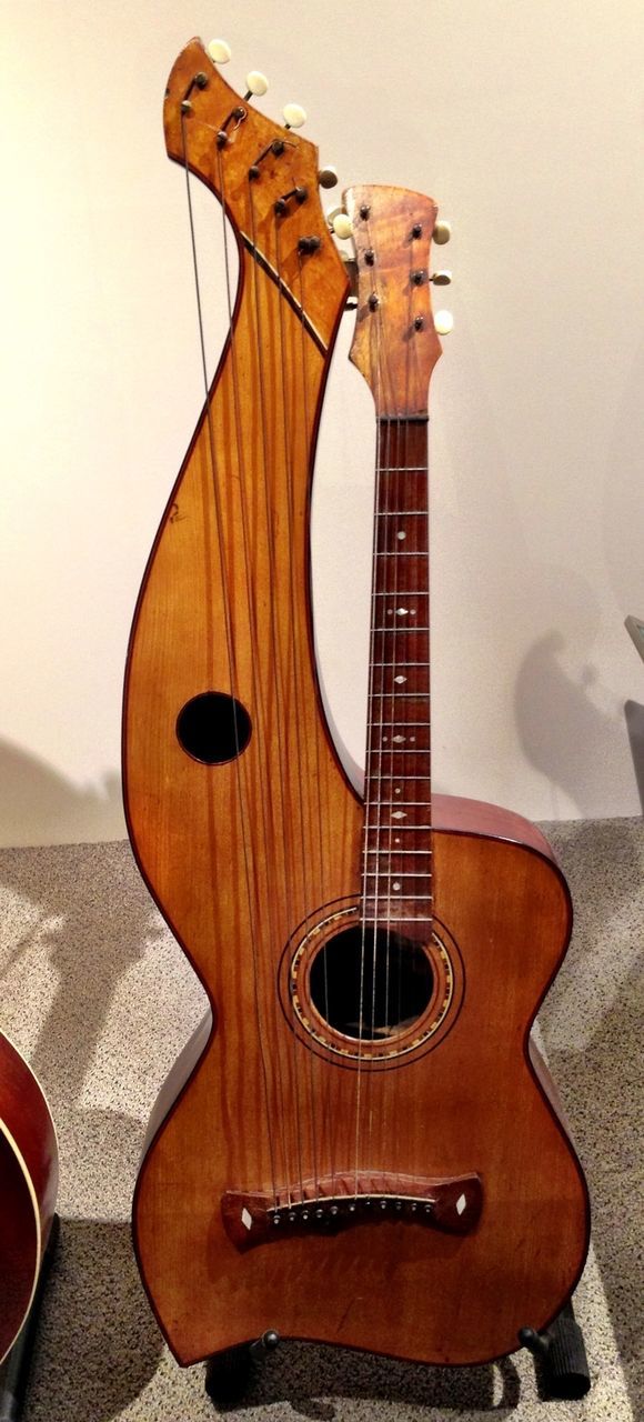 musical instrument, music, guitar, arts culture and entertainment, indoors, musical equipment, musical instrument string, acoustic guitar, string instrument, still life, close-up, wood - material, home interior, hobbies, no people, single object, table, studio shot, chair, retro styled