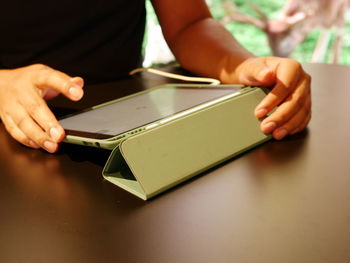 Midsection of woman reading book on table