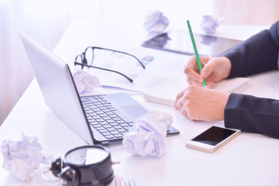 Close-up of man using laptop on table