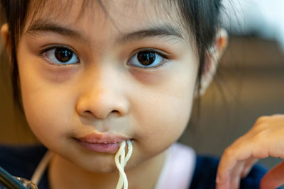 Close-up portrait of cute girl eating food