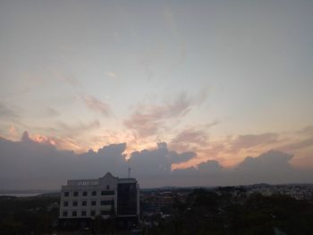 Exterior of buildings in city against sky at sunset