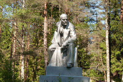 Statue against trees at cemetery