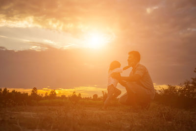 People on field against sky during sunset