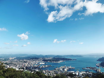 High angle view of townscape by sea against sky