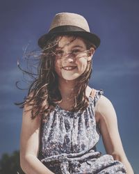 Portrait of a smiling girl wearing hat against sky