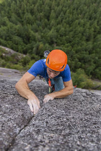 Climber looking up really focused on next hard move while climbing