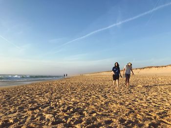 People at beach against sky