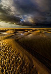 Scenic view of beach against cloudy sky