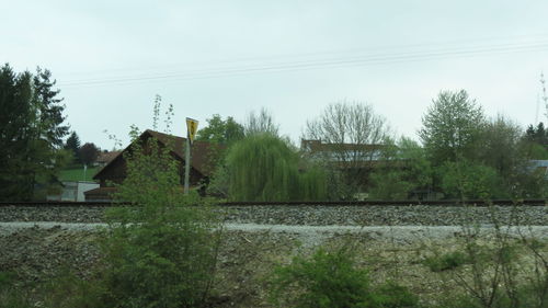 Houses by trees against sky