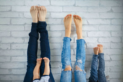 Low section of woman standing against wall