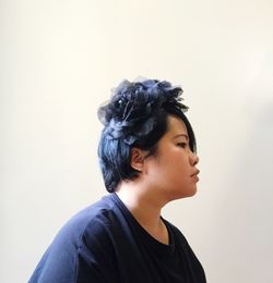 Portrait of young woman looking away against white background