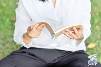 Midsection of woman holding book