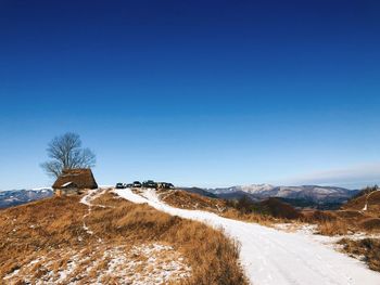 Scenic view of snowcapped mountains against clear blue sky