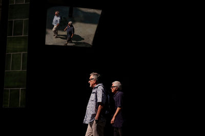 Rear view of man and woman walking on street