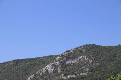 Low angle view of mountain against clear blue sky