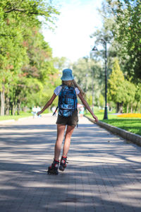 Rear view of girl walking on road