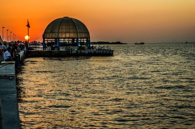 Pier on sea at sunset